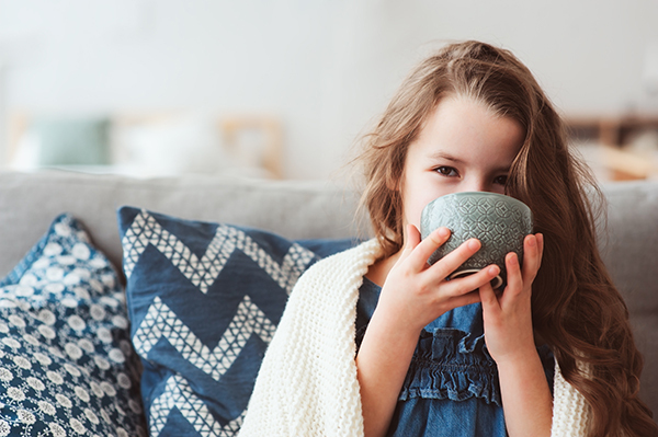 Girl with blanket and warm drink