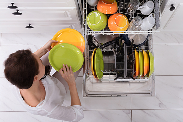 Woman loading dishwasher